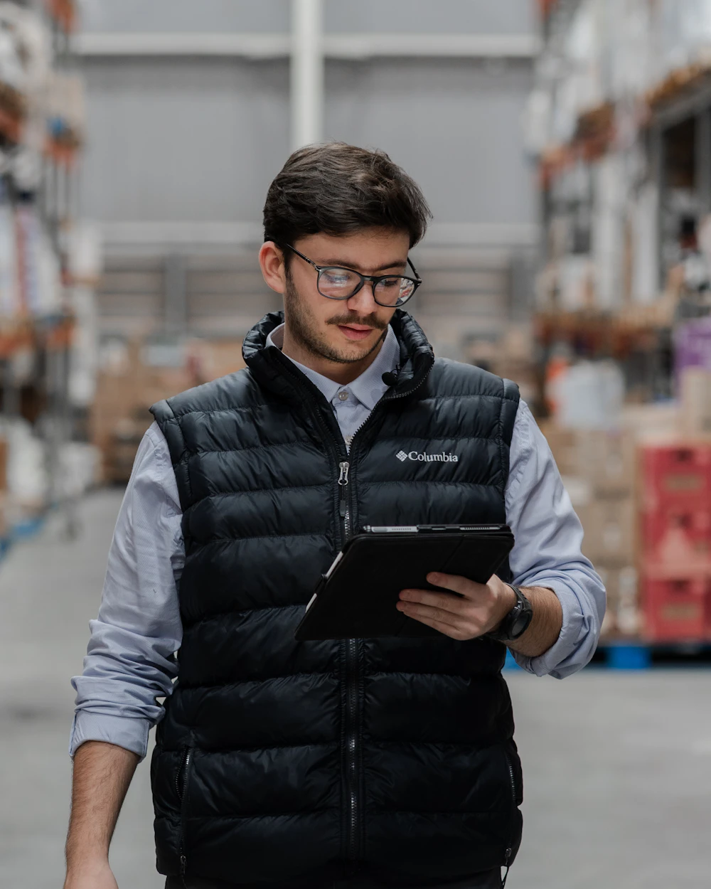 Business owner checking online orders on a tablet in his warehouse